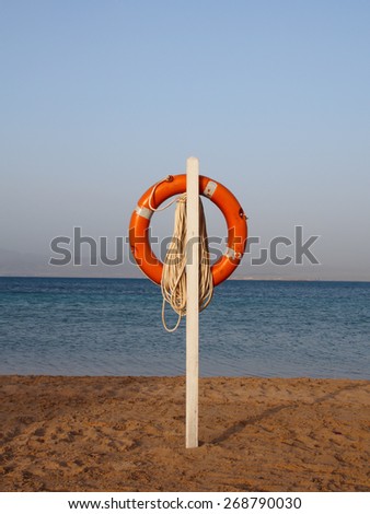 Life buoy ring on the sand beach at sunrise