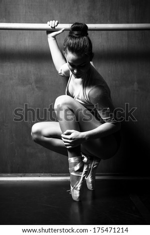 a young ballerina practicing in the hall, black and white