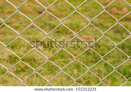 Wire Mesh Fence Close-Up on Green Background