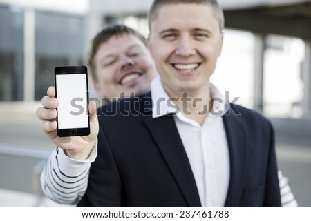happy friends holding smartphone frame