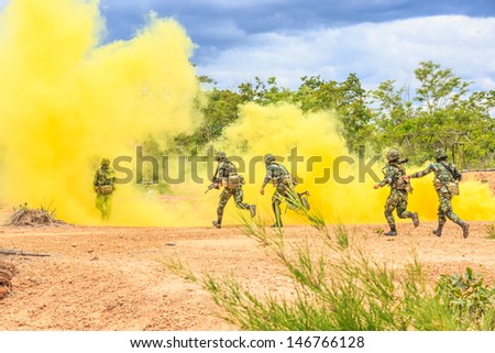 soldiers running behind yellow smoke screen