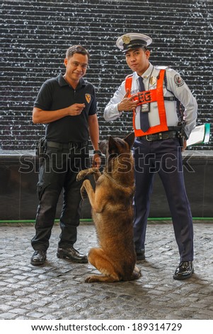 MANILA - FEB 12: Unidentified security guards with dog at Diamond Hotel on 12 Feb, 14 in Manila. It is estimated 3.7 million of security guards including doormen in the Philippines.
