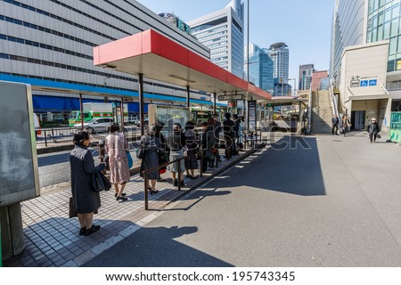 OSAKA - APR 7: People wait for the bus on Apr 7, 14 in Osaka, Japan. It is a city in the Kansai region of Japan's main island of Honshu, a designated city under the Local Autonomy Law.