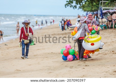 PATTAYA, THAILAND - SEP 15: Local merchant sell swim tubes to tourists at Pattay beach on Sep 15, 13, it is a city in Thailand, a beach resort popular with tourists and expatriates.