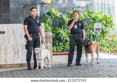 MANILA - FEB 12: Unidentified security guards with dogs at Diamond Hotel on 12 Feb, 14 in Manila. It is estimated 3.7 million of security guards including doormen in the Philippines.