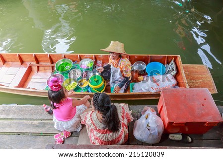 BANGKOK - AUG 2: Unidentified people at Taling Chan Floating Market on Aug 2,14 in Bangkok. The market sale food items, offered on rafts, and in paddle boats with the genuine atmosphere of the riverside.