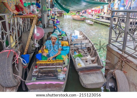 BANGKOK - AUG 2: Taling Chan Floating Market on Aug 2, 14 in Bangkok. The market sale food items, offered on rafts, and in paddle boats with the genuine atmosphere of the riverside.