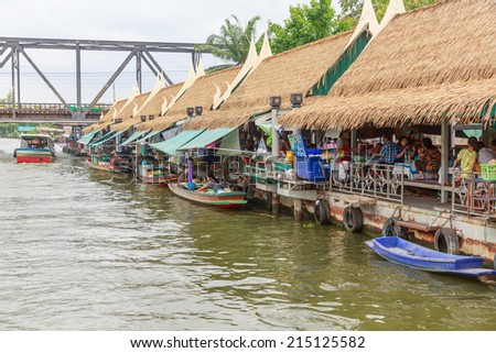 BANGKOK - AUG 2: Tourists visit Taling Chan Floating Market on Aug 2, 14 in Bangkok. The market sale food items, offered on rafts, and in paddle boats with the genuine atmosphere of the riverside.