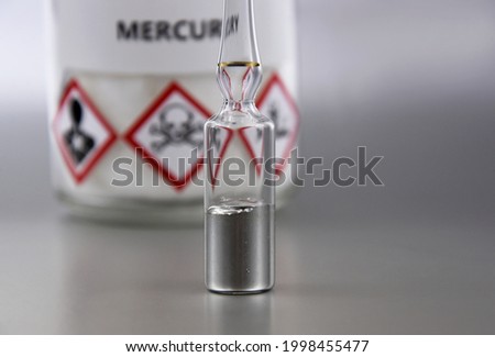 Mercury chemical element stock images. Laboratory accessories images. Mercury in a sealed ampoule stock photo. Laboratory equipment on a silver background. Hg, toxic chemical element stock images Сток-фото © 