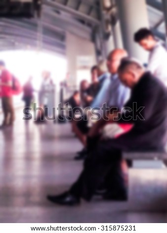 People waiting for Airport-link train in sky train station in Bangkok, Thailand blurred background
