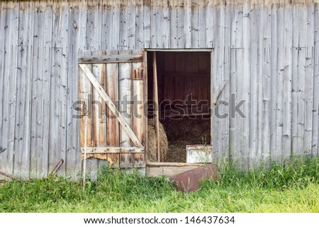 open door in an old barn with hay
