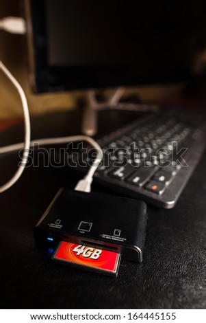 Card reader with 4GB compact flash card plugged to the black computer