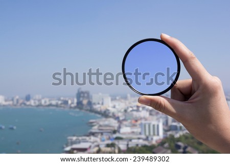 hand is holding filter with landscape