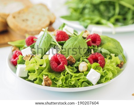 Fresh salad with lettuce, baby spinach, ruccola, raspberries feta and nuts