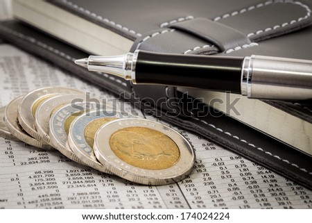 financial report with coins and pen
