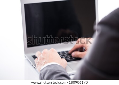 Close-up of male hands typing on laptop keyboard