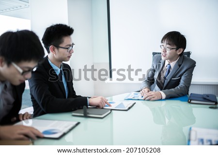 Young business people sitting in board room during meeting and discussing with paperwork.Asian