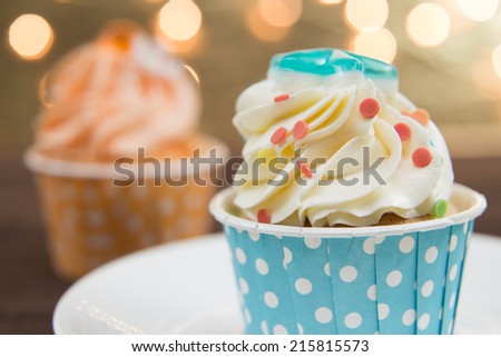 Tasty cupcake with butter cream on lights background