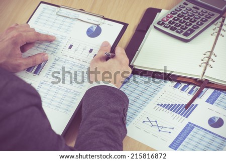man hand with pen and business report. Accounting