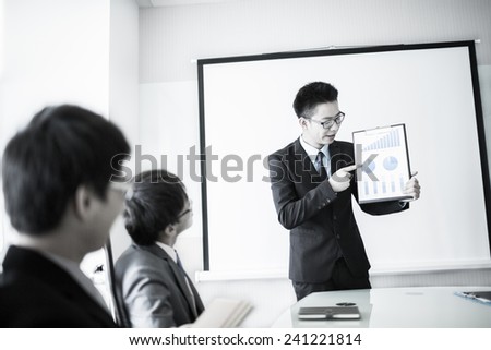 Smiling businessman discussing plans with his colleagues in board meeting.asian