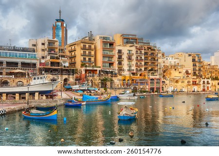 MALTA - JANUARY 23 2015: Spinola Bay with boats in front of famous touristic restaurants and Portomaso tower at back at St Julian, Malta