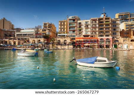 MALTA - MARCH 22 2015: Spinola Bay with boats in front of famous touristic restaurants and Portomaso tower at back at St Julian, Malta