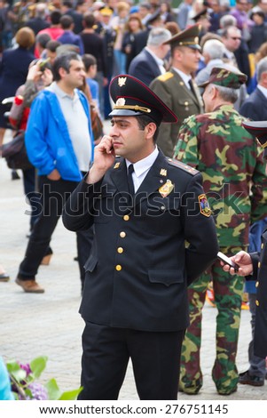 Armenian soldiers in black uniform dress talking on cell phones. Police forces. May 9, 2015