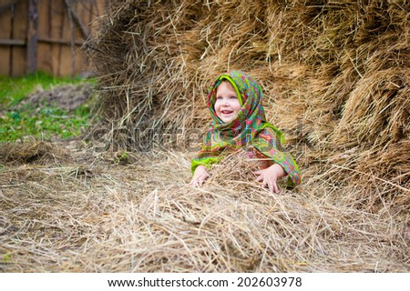 Close up image of beautiful little girl in russian village traditional kerchief with round cracknel with russian ornamen over autumn weather/Lovely russian Baby girl