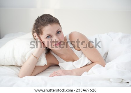 young woman sleeping on the white linen in bed at home, top view