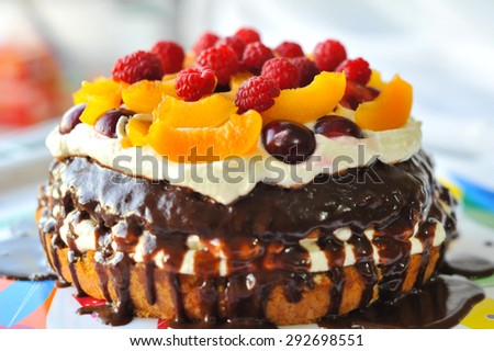 Cake with fruit, berries and butter cream, raspberry, peach, cherry, chocolate