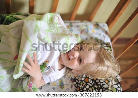 Adorable sleepy baby girl woke up in the morning in bed
