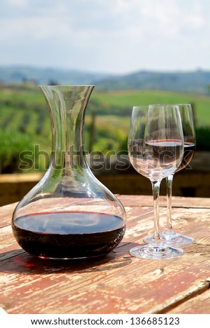 Red wine in a wine carafe and a two wine glasses in vineyard