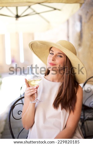 Young happy woman with glass of white wine