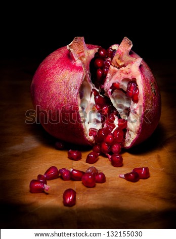Pomegranate: Studio still life shot of a pomegranate broken open to reveal the seeds.