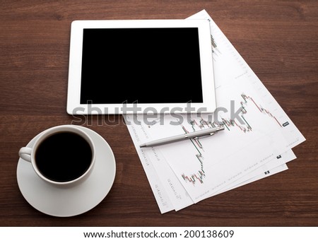 Digital tablet on wooden tablets with documents and pen