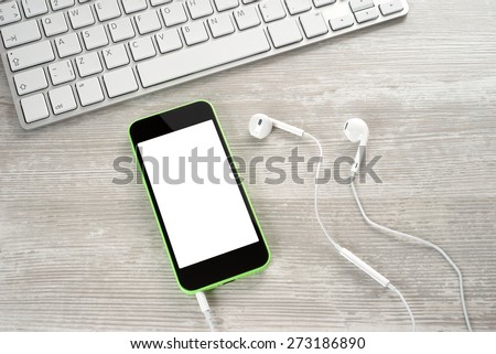 White headphones with the phone and keyboard closeup