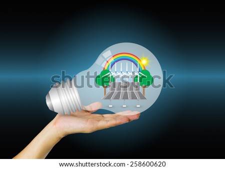Bulb and alternative energy in hand with blue background.