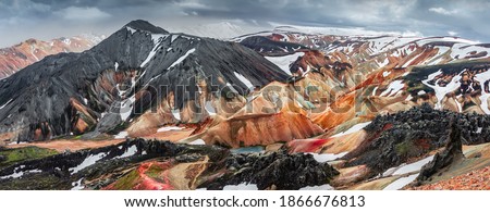 Panoramic amazing Icelandic landscape of colorful rainbow volcanic Landmannalaugar mountains, at famous Laugavegur hiking trail with dramatic snowy sky, and red volcano soil in Iceland. Photo stock © 