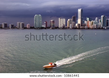 Miami skyline and Biscayne Bay with brightly colored power boat in foreground.
