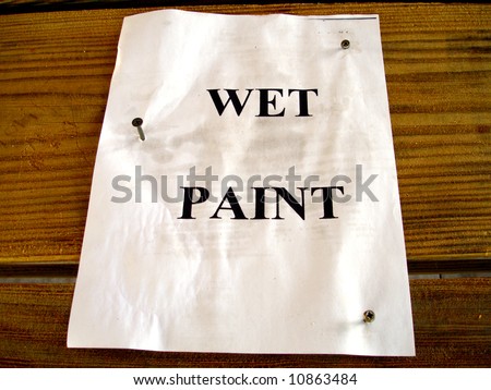 Wet-paint sign screwed to wood picnic table.