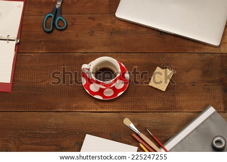 Coffee break on wooden table with office supplies - top view