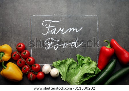Fresh Vegetables on grey kitchen countertop with Farm Food chalk lettering