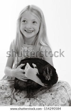pretty blonde girl holding a chicken, isolated on white background in monochrome