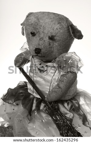Black and white Vintage teddy bear dressed as a Halloween witch isolated on white background