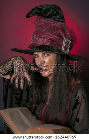 Halloween witch casting spells on red background