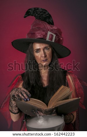 Halloween witch casting spells, with cauldron on dark background
