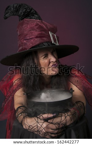 Halloween witch casting spells, with cauldron on dark background