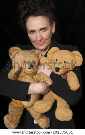 Vintage 1940's style woman in office cuddling a teddy bear, isolated on black background