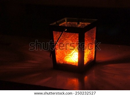 Red lantern on the window with a candle, good for Valentines day or Halloween, selective focus on the flame