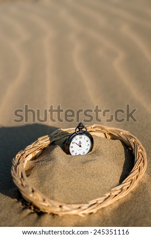 Pocket watch buried in sand